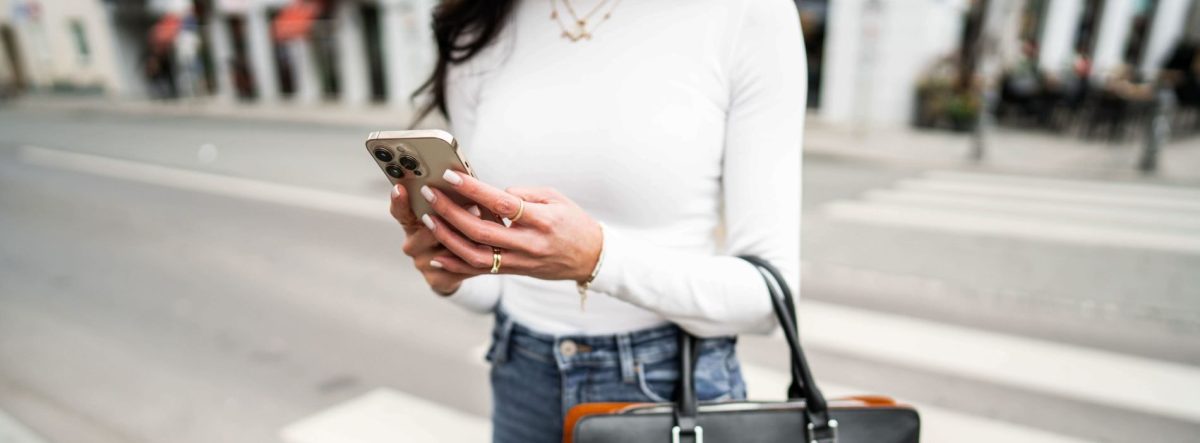 Frau arbeitet unterwegs auf dem Smartphone